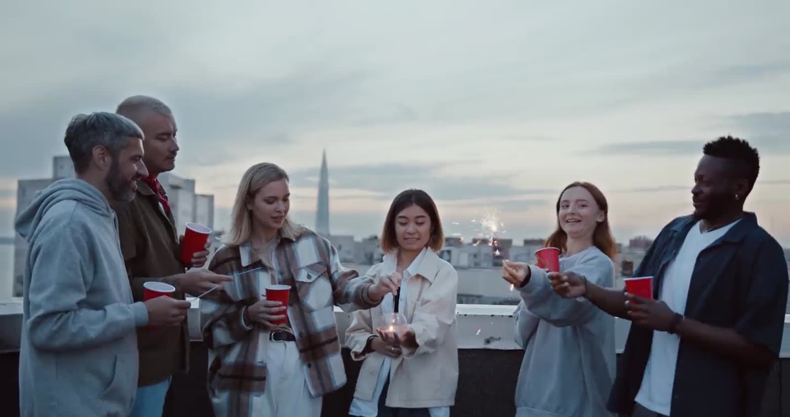 Travellers meeting on a rooftop at dusk